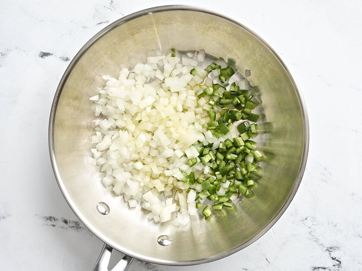 Onions and jalapeno in a saute pan.