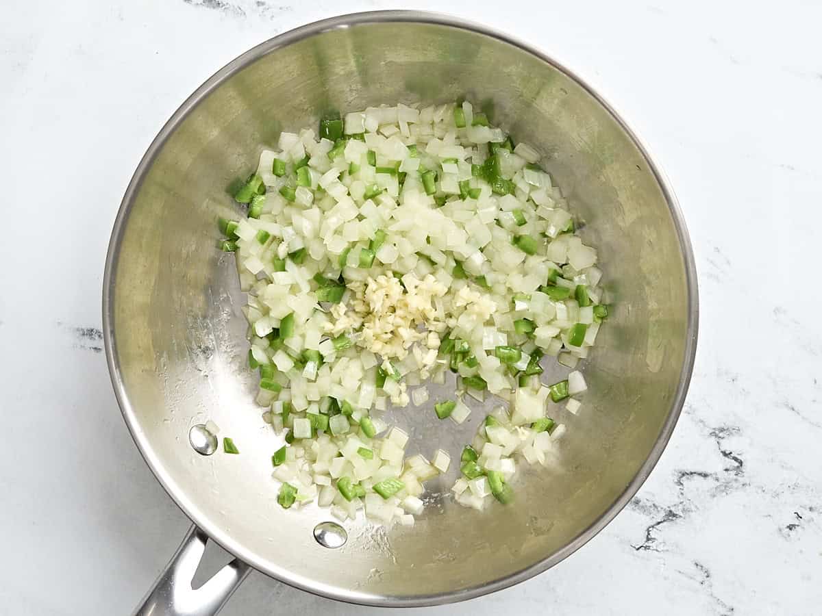 Onions and jalapenos with minced garlic in a saute pan.