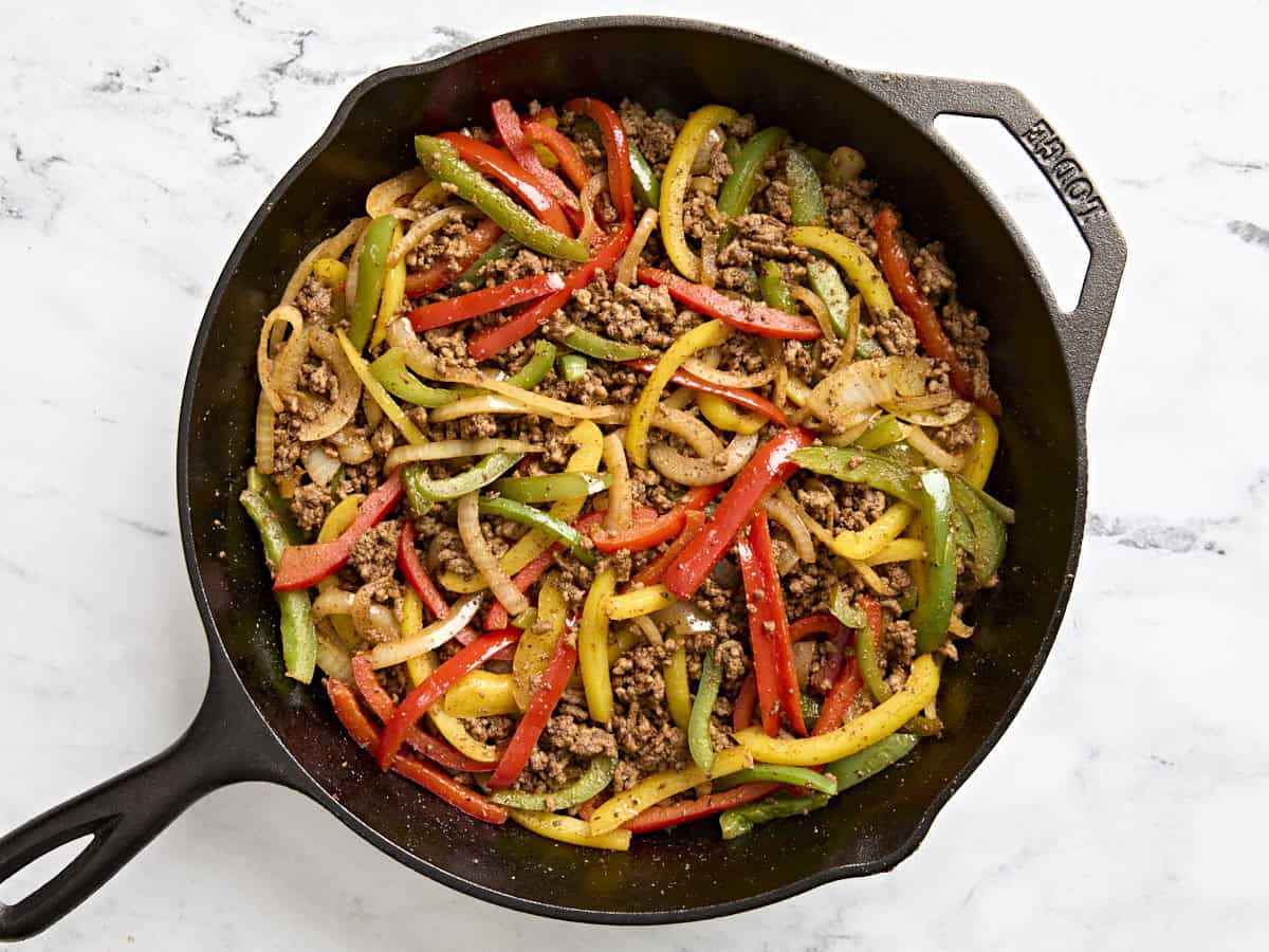 Overhead view of ground beef fajitas in a cast iron skillet.