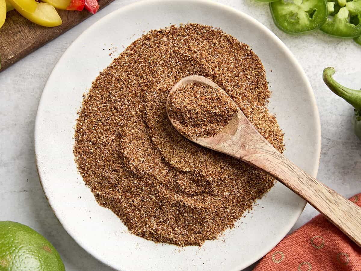 Overhead view of fajita seasoning with a spoon on a plate.