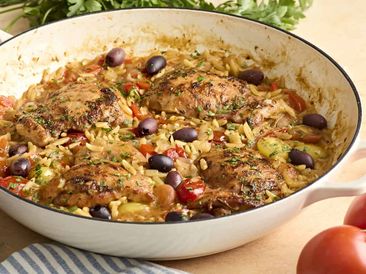 Side view of Greek chicken and orzo in a skillet.