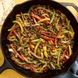 Overhead view of ground beef fajitas filling in a skillet.