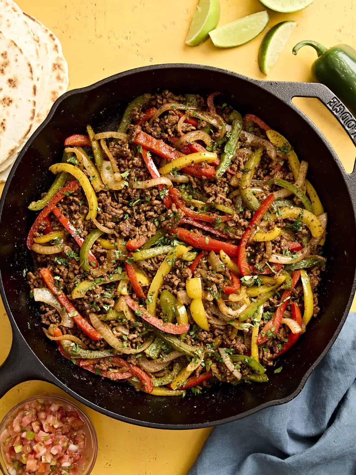 Overhead view of ground beef fajitas filling in a skillet.