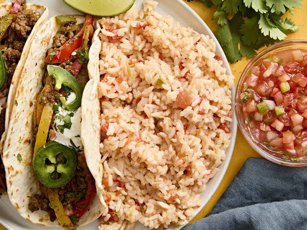 Overhead view of Spanish rice on a plate with a taco.