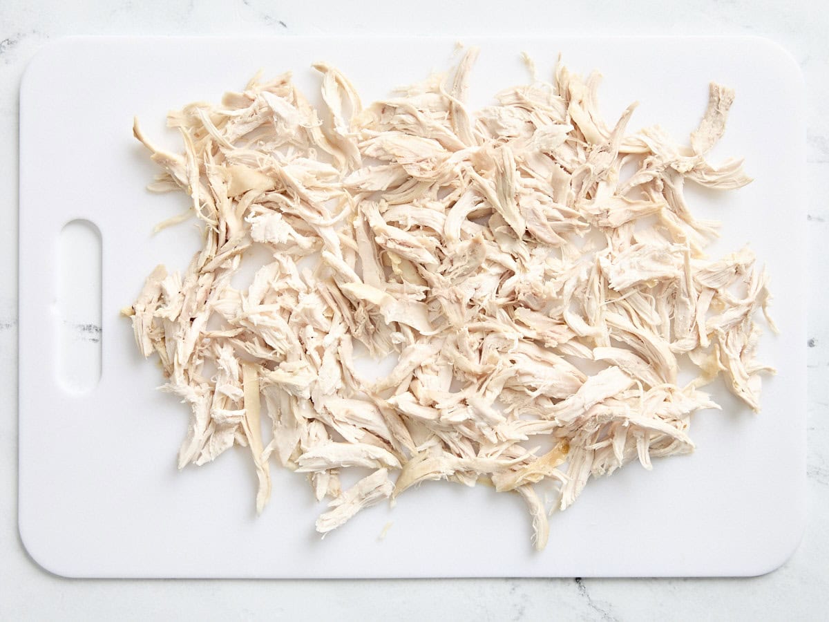 Shredded chicken on a cutting board.