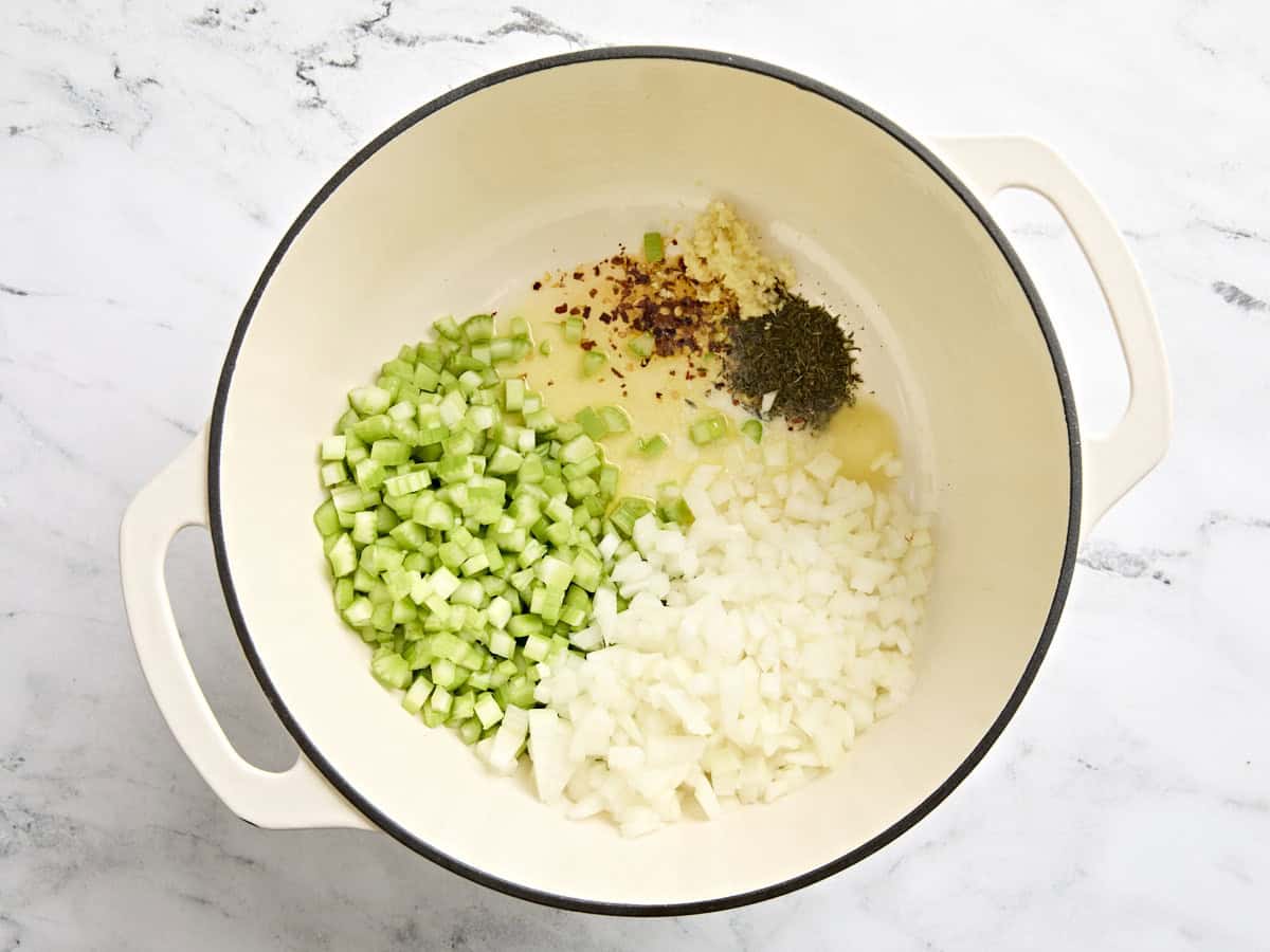 Diced onions, diced celery. minced garlic, and seasonings in a sauce pot.