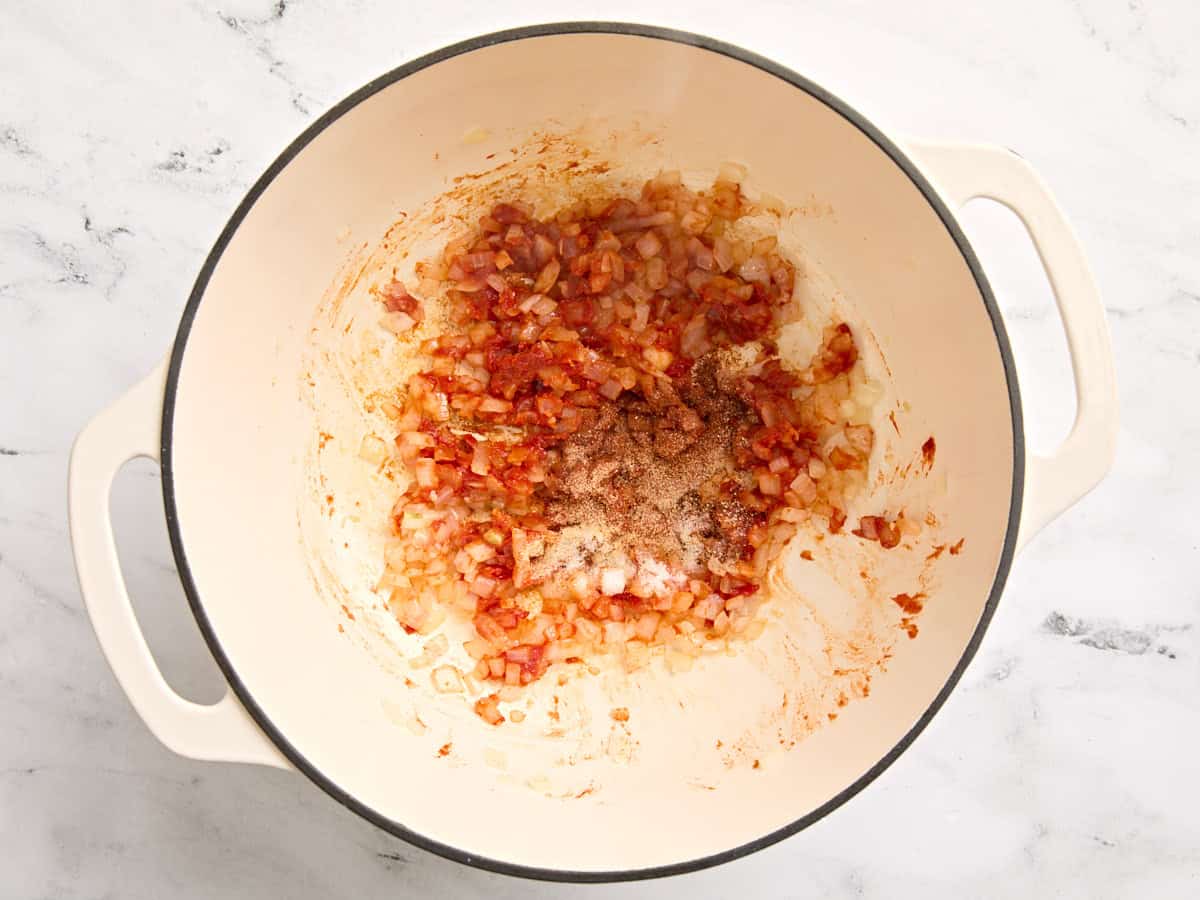 Spices added to diced onion in a pot.