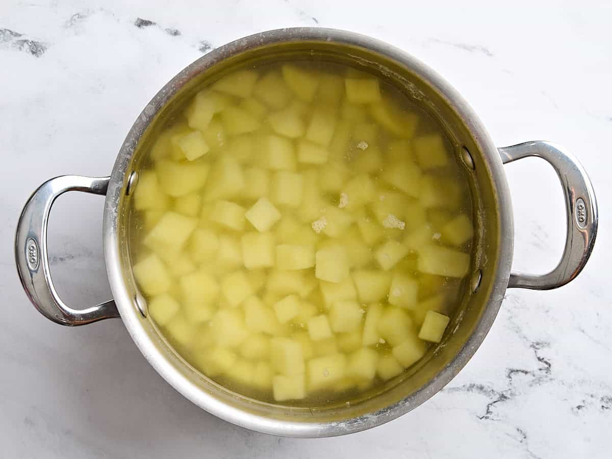 Diced potatoes in a sauce pan of water.