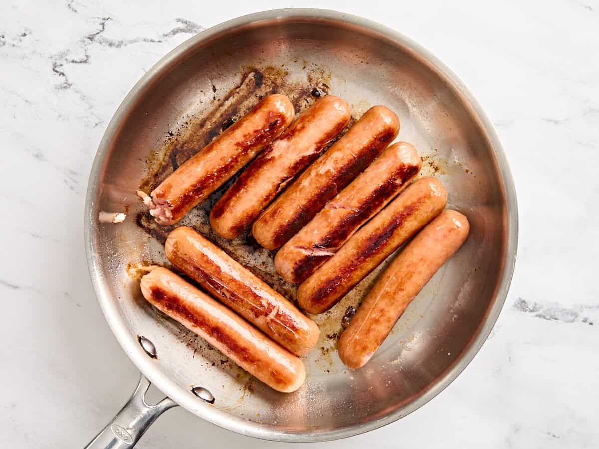 Cooked sausages in a skillet.