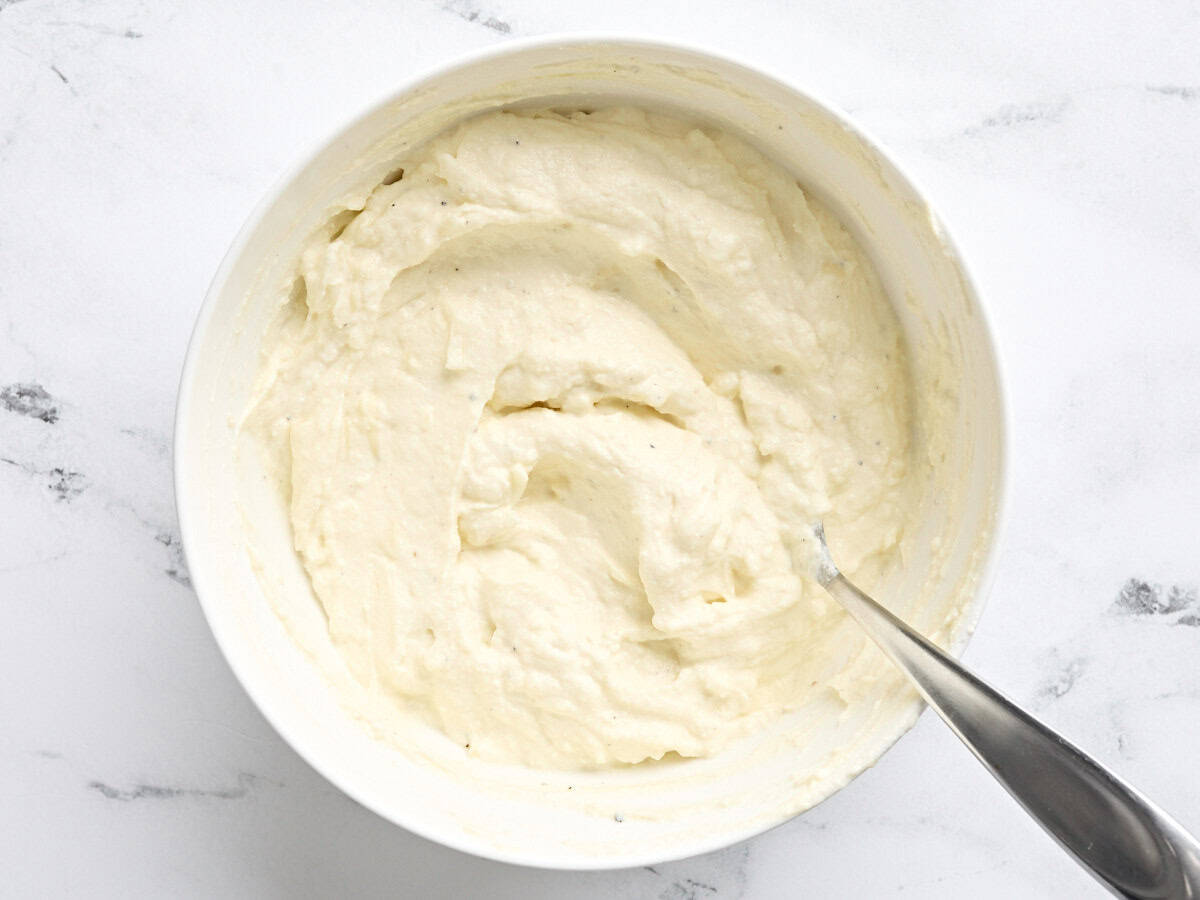 A ricotta cheese mixture in a bowl for homemade white chicken lasagna.