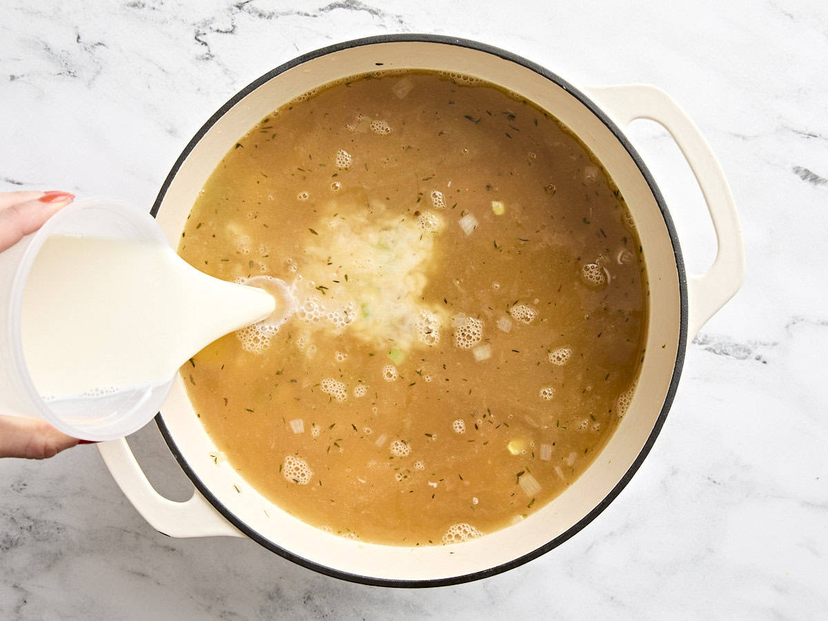 Milk being poured into the potato corn chowder.