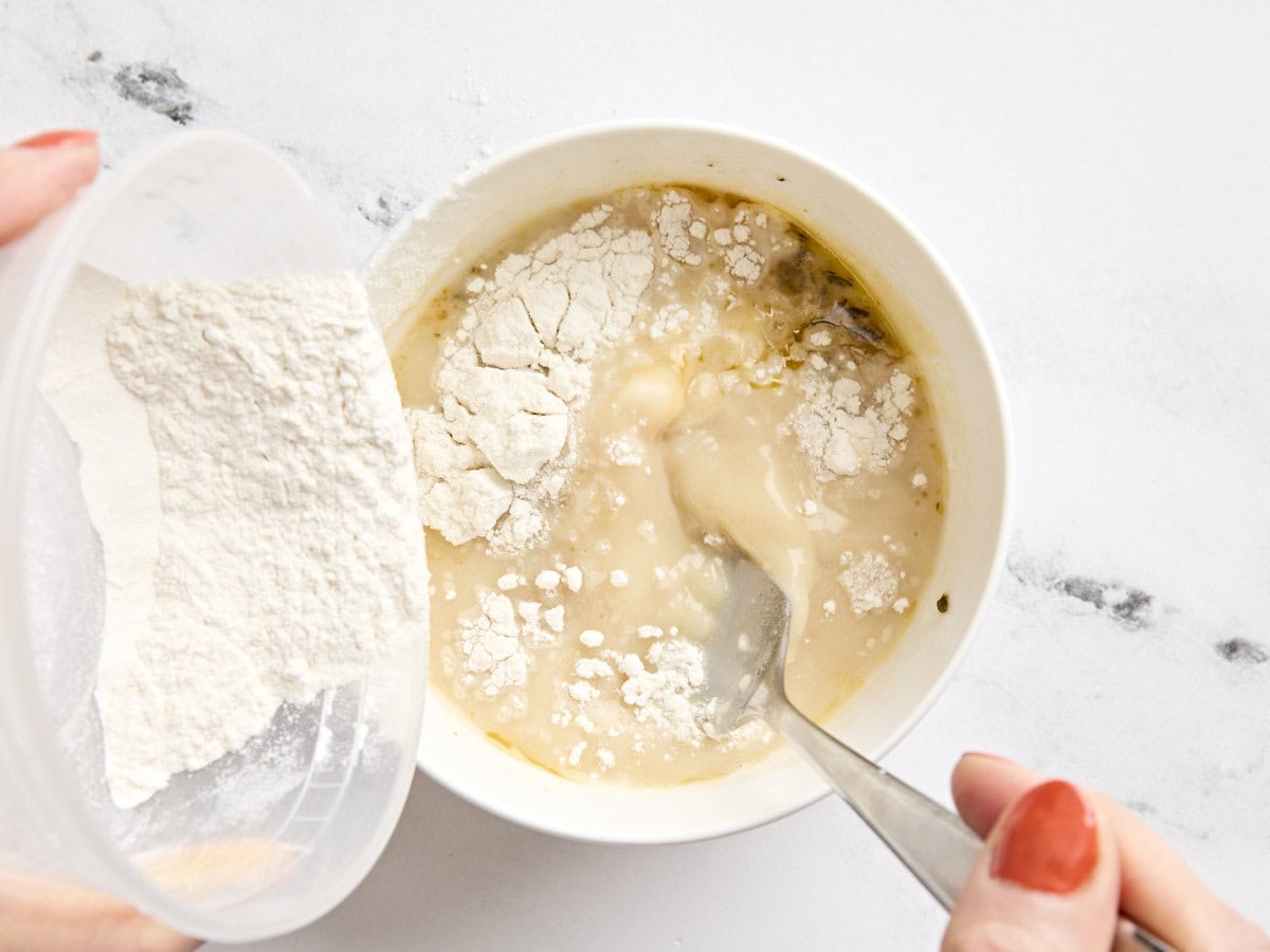 Cornflour being mixed with some potato and corn chowder in a small bowl to make a slurry.