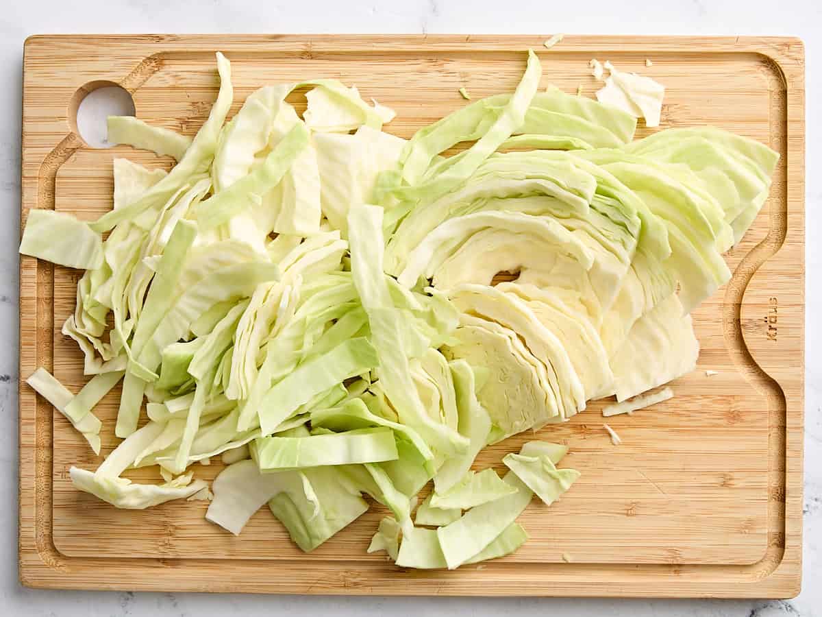 Chopped cabbage on a wooden cutting board.