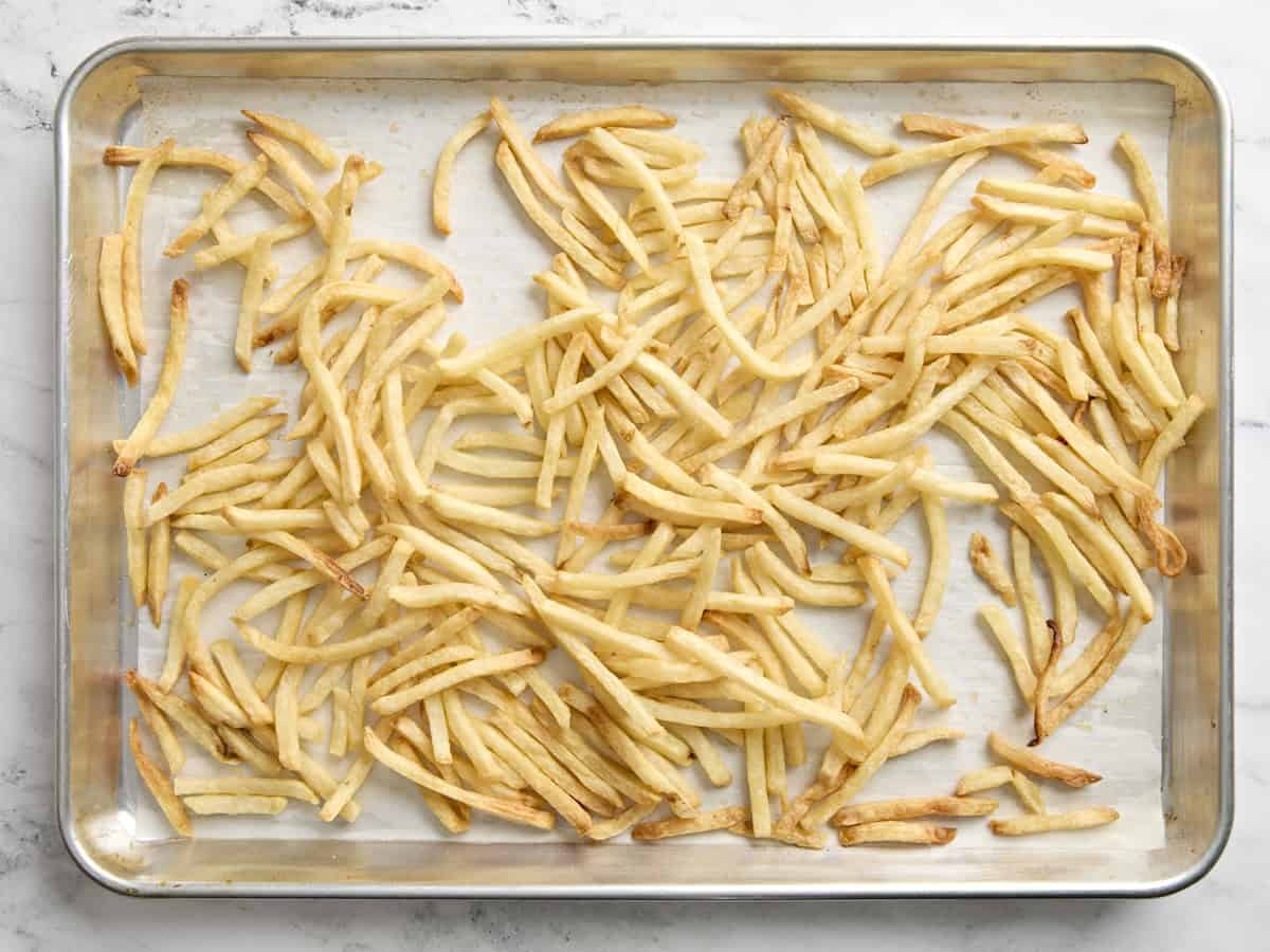 Freshly baked fresh fries on a baking sheet.