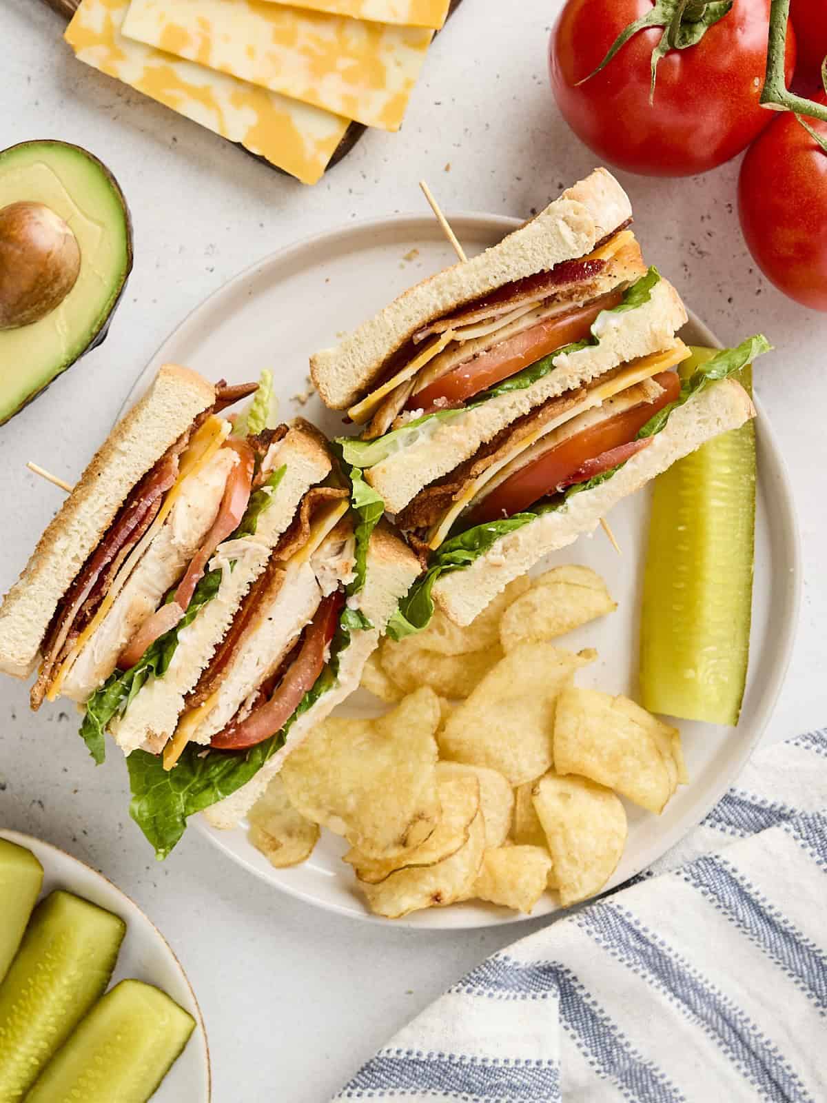 overhead view of chicken club sandwich on a plate with all the fixings