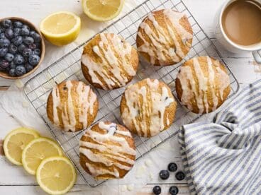 Overhead view of lemon blueberry muffins on a wire rack.