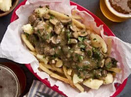 Overhead view of poutine in a red basket.