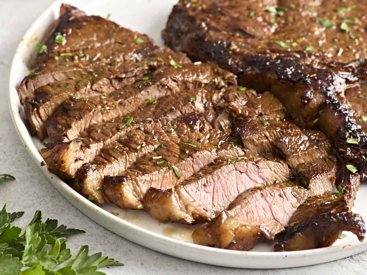 Side view of a marinated steak on a plate.