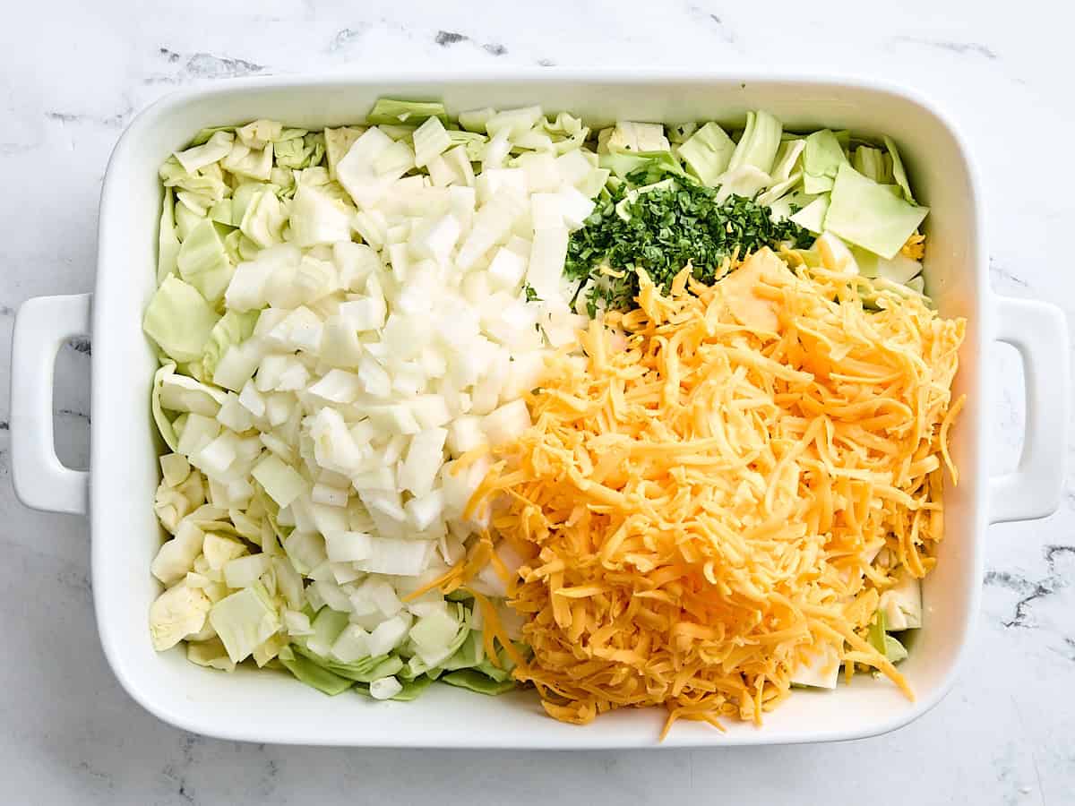 The ingredients for cabbage casserole in a casserole dish.