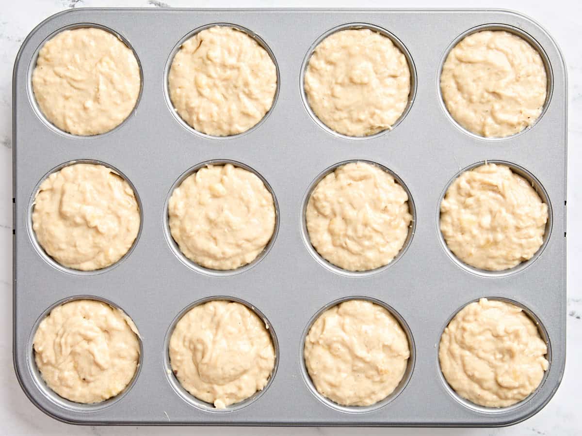 Banana muffin batter in a muffin pan.