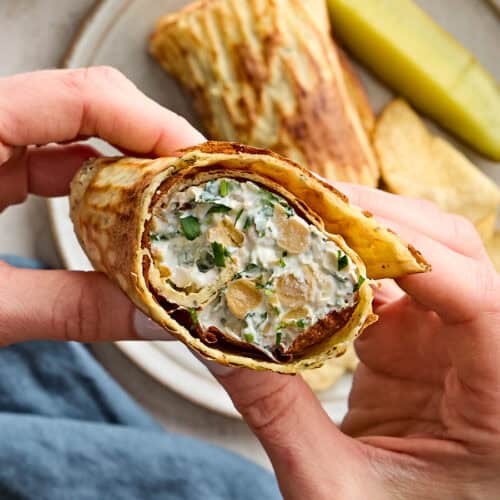 Overhead view of hands holding a cottage cheese wrap.